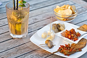 Mojito cocktail with snacks on wooden table