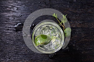 Mojito cocktail from top, vodka or soda drink with lime mint isolated on black wooden background