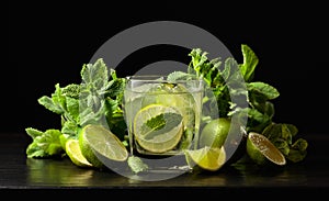 Mojito with ice, lime, and mint on a black background