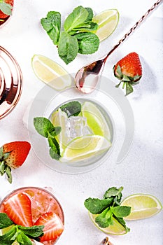 Mojito mocktail or cocktail with lime, mint, strawberry and ice on white background. Cold alcoholic or non-alcoholic long drinks,