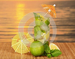 Mojito with umbrellas against sea sunset