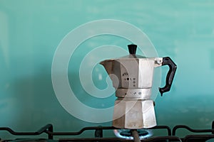 Moka coffe on gas flame. Italian typical coffee tool. Espresso coffe with light blue background and copy space photo