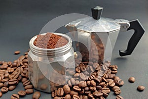 Moka coffee pot with coffee beans on moka base isolated on black background