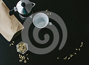 Moka pot on black background with cardamon seeds