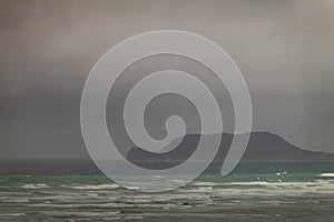 Mokolii island under rainy clouds off east coast, Oahu, Hawaii, USA