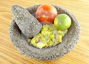 Molcajete Mortar Bowl and Pestle Filled With Guacamole And Ingredients