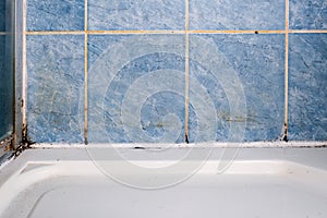 Mold fungus and rust growing in tile joints in damp poorly ventilated bathroom with high humidity, wtness, moisture and