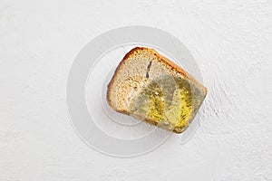 Moldy bread. Wasted, spoiled and moldy food on a gray background.
