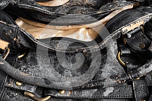 Moldy leather bag on dark background close up