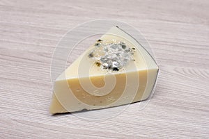 Schimmlig ein stück aus Käse auf der hölzern das licht Oberfläche 