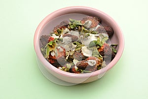 Moldy strawberries in pink dish