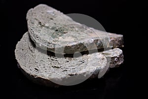 Moldy white bread on a black background.