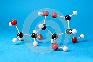 Molecule of glucose on light blue background. Chemical model