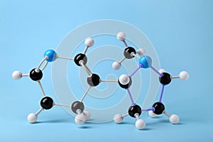 Molecule of nicotine on light blue background. Chemical model