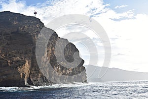 Molokini Crater rock from the Pacific Ocean, mountain in the background, Hawaiian Island of Maui