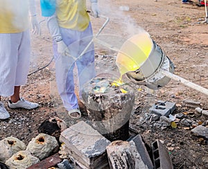 Molten bronze is poured into the mold.