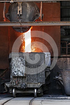 Molten copper is pouring to melting pot of the transport vehicle with rail.