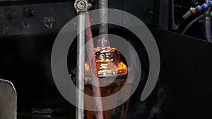 Molten glass on end of punty rod getting shaped in glass blowing shop