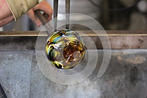 Molten glass on a metal rod for glass blowing macro