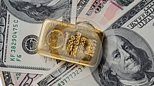 Molten gold bar weighing 250 gram against the background of dollar bills