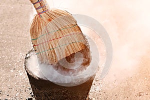 Molten hot tar in a bucket on the bricks. Roof repair tar from a bucket with a broom