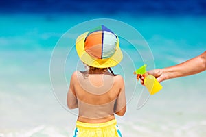 Mom applying sunscreen on child. Safe beach fun