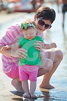 Mom and baby on beach have fun