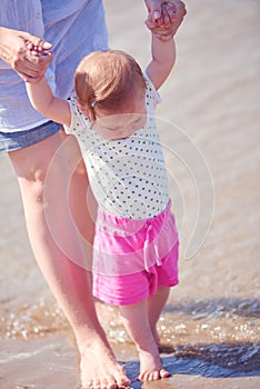 Mom and baby on beach have fun