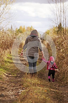 Mom and Baby Daughter with Teddy Walking on Gravel