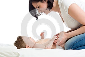 Mom with baby. Infant weared diaper lying on bed