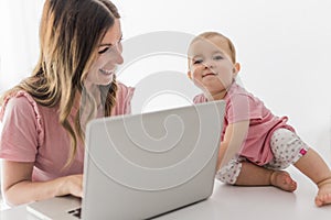 Mom and baby with laptop computer working from home