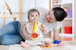 Mom and baby playing musical toys at home