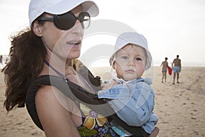 Mom and baby in rucksack at beach