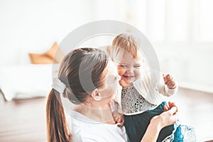 Mom and baby are sitting at home and smiling cheerfully