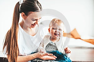 Mom and baby are sitting at home and smiling cheerfully