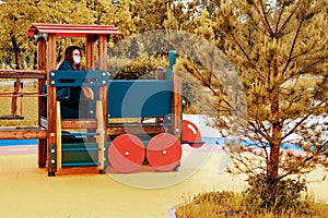 Mom baby sitting in a toy train in the playground