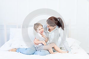 Mom and baby talking at home on the bed, the concept of the relationship between parents and children