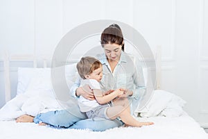 Mom and baby talking at home on the bed, the concept of the relationship between parents and children