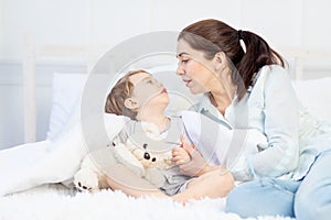 Mom and baby talking at home on the bed, the concept of the relationship between parents and children