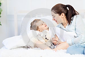 Mom and baby talking at home on the bed, the concept of the relationship between parents and children