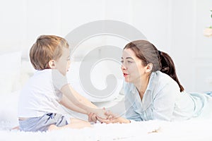 Mom and baby talking at home on the bed, the concept of the relationship between parents and children