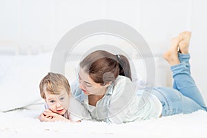 Mom and baby talking at home on the bed, the concept of the relationship between parents and children