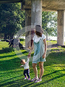 Mom and baby walk in the upland park on a sunny summer day