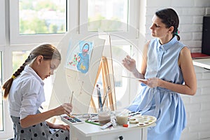 Mom and blackboard are fond of painting and draw sitting by the window on a weekend photo