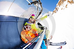 Mom with boy on ski lift ropeway chair