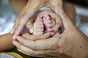 Mom and brother holding baby's feet