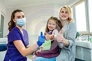 mom brought her little daughter to the dentist's office to treat baby teeth.