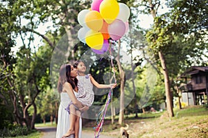 Mom carrying his daughter with nature and sunlight, enjoyment family