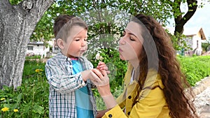 Mom and child blow out a dandelion