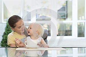 Mom with child in cafe drinks coffee. Babysitter and toddler. Happytime